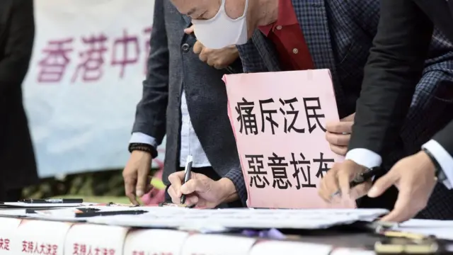 多个省级同乡社团在香港上环举行“支持人大决定踢走揽炒议员”大签名行动启动仪式(中新社图片12/11/2020)