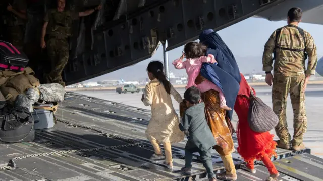 आई आणि मुलं C-17 विमानात चढाताना