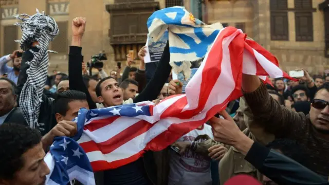 Egyptian protestors burn the Israeli and American flags during a demonstration against US President Donald Trump's decision to recognize Jerusalem as the capital of Israel at the al-Azhar mosque in Cairo on December 8, 2017.
