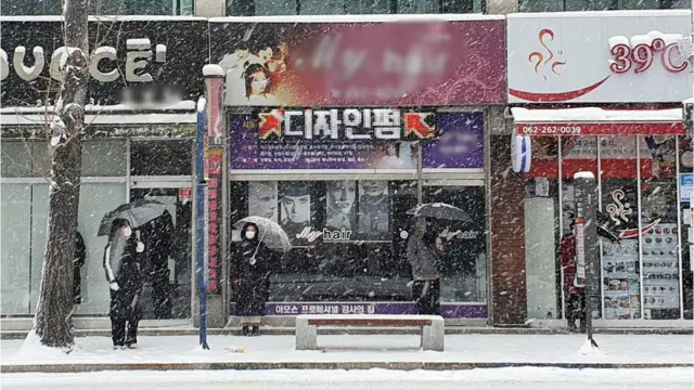 폭설에 우산 쓴 시민들. 대설 경보가 내린 7일 오전 광주 북구 오치동 한 버스정류장에서 시민들이 우산을 쓰고 버스를 기다리고 있다