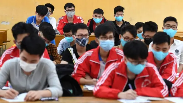 Students, wearing facemasks amid concerns of the COVID-19 novel coronavirus outbreak, study inside a classroom at the University of Science and Technology in Hanoi