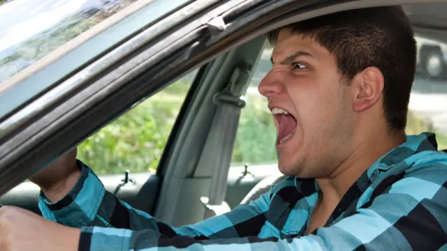 Hombre conduciendo un auto e insultando