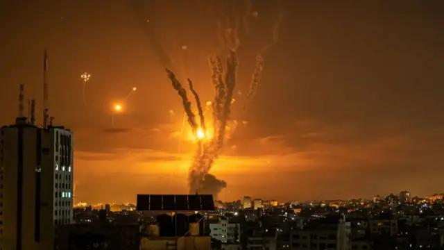 Tên lửa được phóng về phía Israel từ phía bắc Dải Gaza và phản ứng từ hệ thống phòng thủ tên lửa Vòm Sắt của Israel được gọi là Vòm Sắt để lại những vệt sáng trên bầu trời hôm 14/5/2021 tại thành phố Gaza, Gaza.