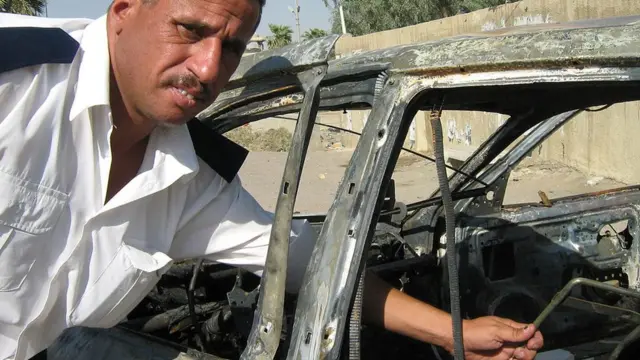 ব্ল্যাকওয়াটার রক্ষীদের গুলিতে ক্ষতিগ্রস্ত একটি গাড়ি পর্যবেক্ষণ করছেন ঘটনাস্থলে প্রত্যক্ষদর্শী একজন ইরকি ট্রাফিক পুলিশ আলি খালাফ- সেপ্টেম্বর ২০০৭