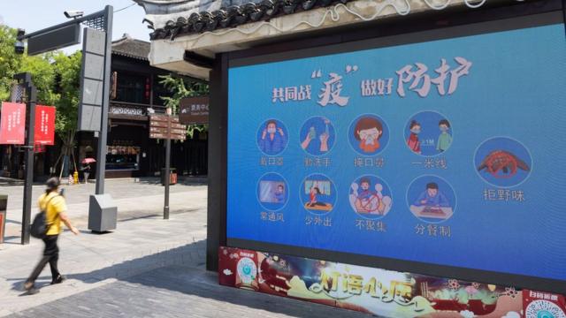 南京市夫子廟景區內的電子屏幕上播放著「共同戰『疫』做好防護」字樣（中新社圖片30/7/2021）