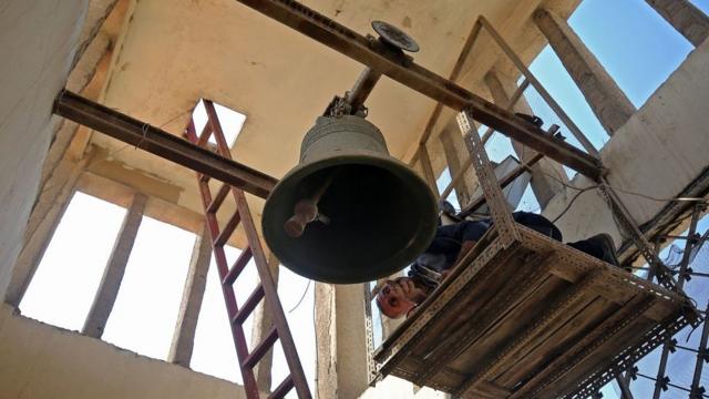 عامل يتفقد جرس كنيسة مار يوسف للكلدان في بغداد