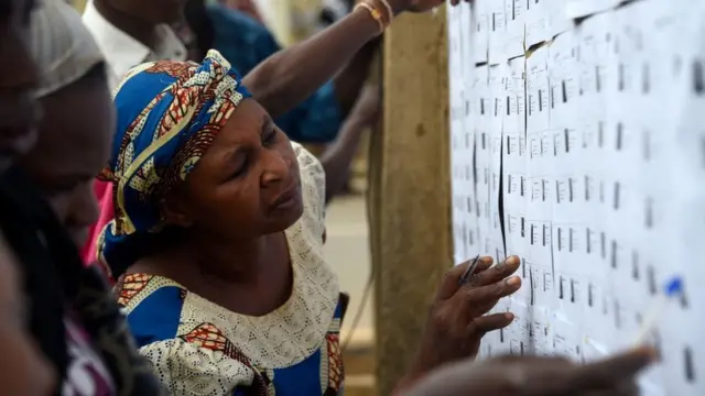 Une femme regarde des papiers sur le mur