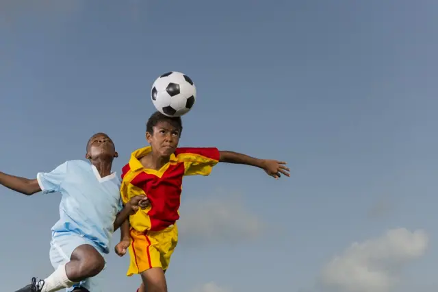 Два мальчика играют в футбол