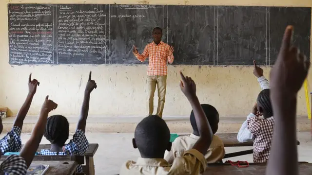 Schoolchildren dey listen to dia teacher for one primary school inside Bouake, central Ivory Coast