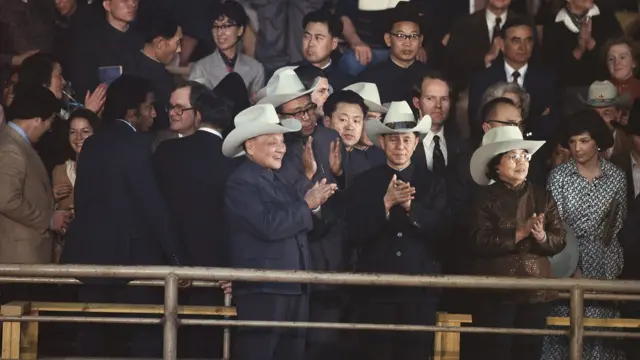 邓小平欣然接过并戴上一个宽边牛仔帽。