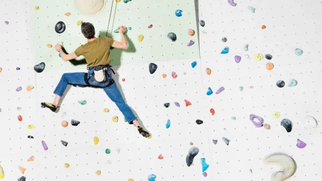 شخص يتسلق جدارا بطريقة صعبة