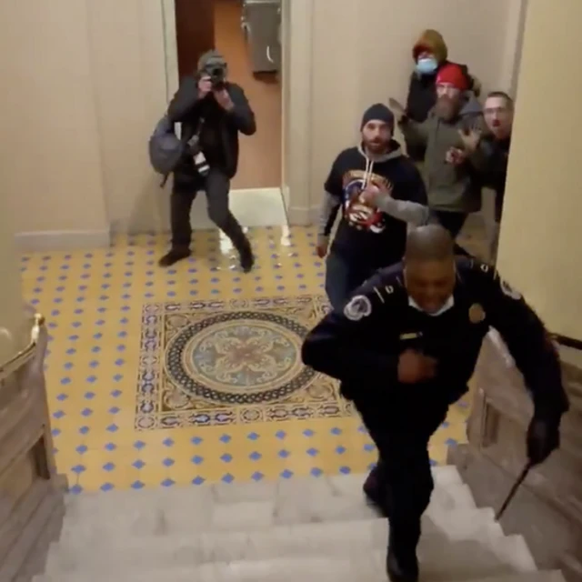 Officer Goodman is chased up a set of stairs by a group of rioters