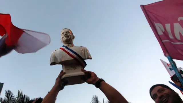 Un busto de Augusto Pinochet es alzado por seguidores del gobierno militar durante una celebración por la victoria de Piñera.