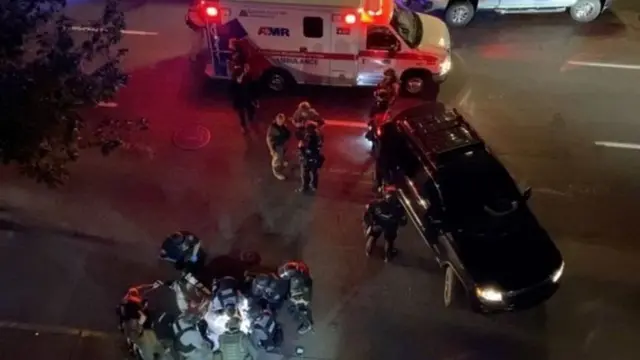 رجال الأسعاف في أثناء محاولتهم، دون جدوى، إنقاذ الرجل الذي أصيب بالرصاص.