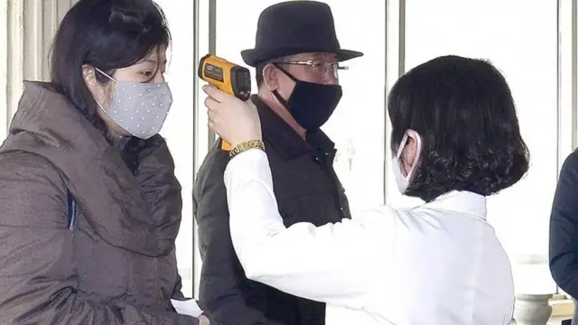 발열 체크를 하고 있는 북한 여성