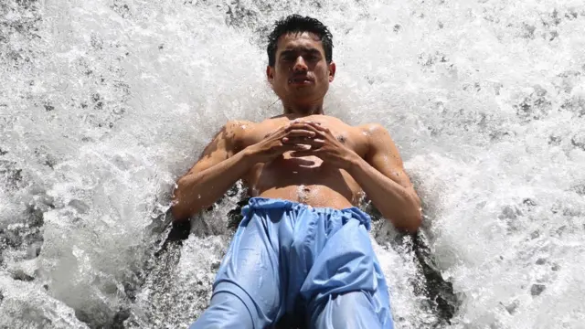 أفغاني يلجأ إلى شلالات المياه للتغلب على موجة الحر في جلال آباد