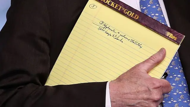 روی دفترچه یادداشتی که دست جان بولتون است نوشته شده: ۵۰۰۰ نیرو به کلمبیا