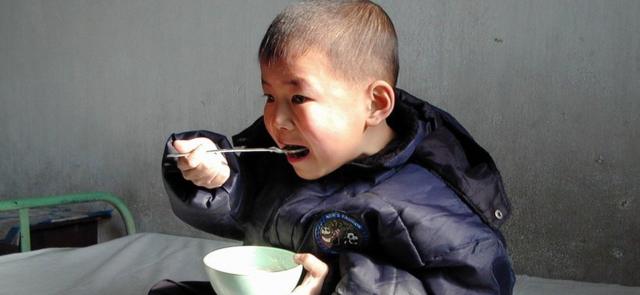 这张2004年的照片中，一名朝鲜男童在食用联合国世界粮食计划署提供的富含维生素及矿物质的食物。