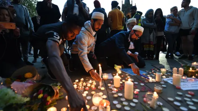 People lighting candles at the vigil in Manchester