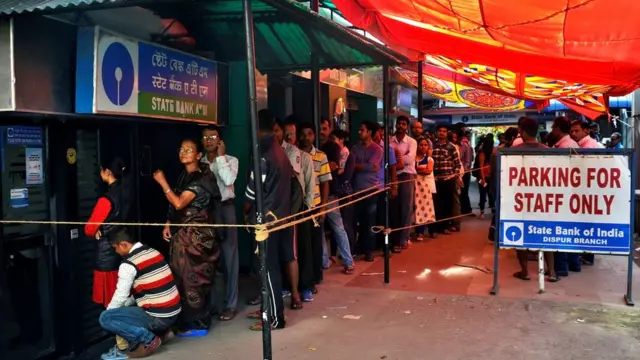 गुवाहाटी में स्टेट बैंक के बाहर पैसे निकालने और जमा करने के लिए लगी लोगों की लंबी कतार