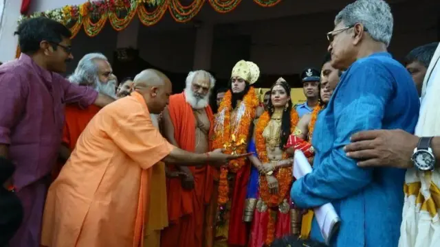 રામ, સીતા અને લક્ષ્મણના વેશમાં આવેલા લોકોની આરતી ઉતારી રહેલા યોગી આદિત્યનાથનો ફોટોગ્રાફ