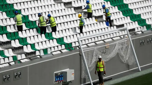 عمال في احد ملاعب البطولة