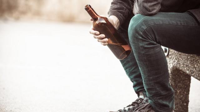 Hombre con una botella de alcohol