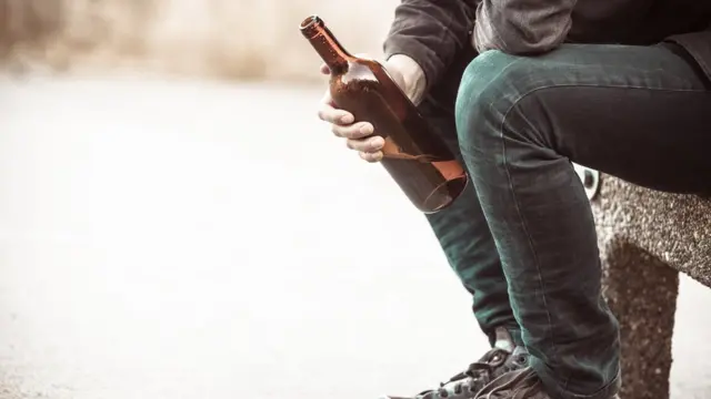 Hombre con una botella de alcohol