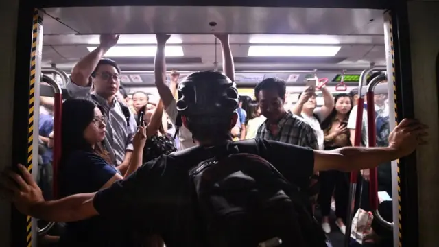 протестующий удерживает двери