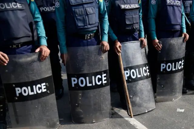 ভেস্ট পরে শিল্ড হাতে দাঁড়িয়ে আছেন পুলিশের চারজন সদস্য, প্রতীকী ছবি