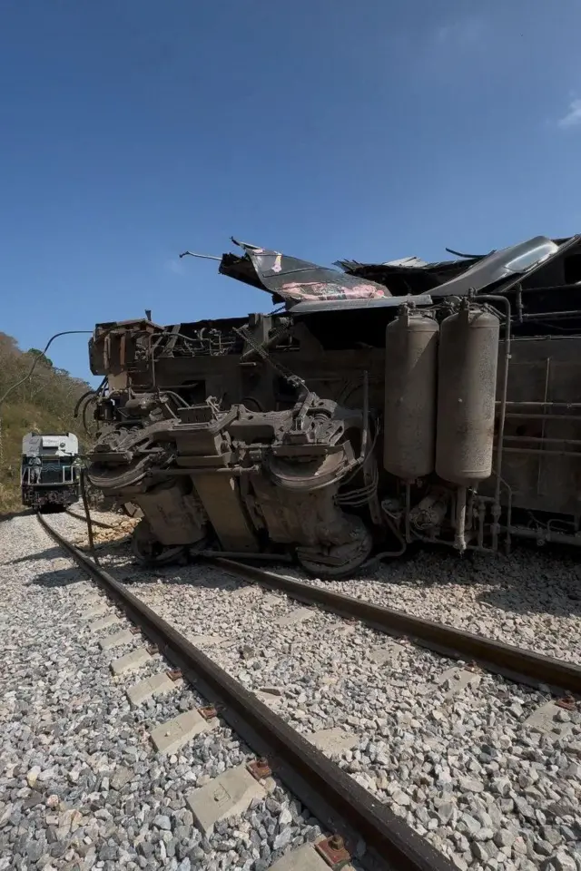 Uno de los vagones del tren volcado sobre la via.