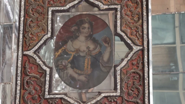 Umetničko delo na zidu prikazuje devojku kako pije iz čaše