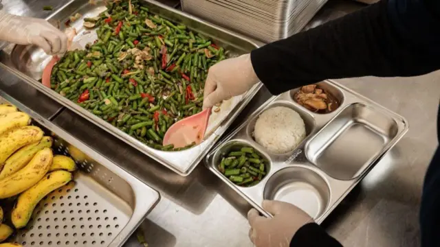 Beberapa pekerja di dapur makan bergizi gratis menyiapkan makanan untuk diantar ke sekolah pada 6 Januari 2025.