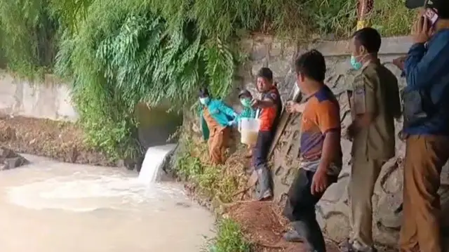 Petugas dari Dinas Lingkungan Hidup Kota Tangerang Selatan mengambil sampel air Sungai Cisadane (09/02/2026).