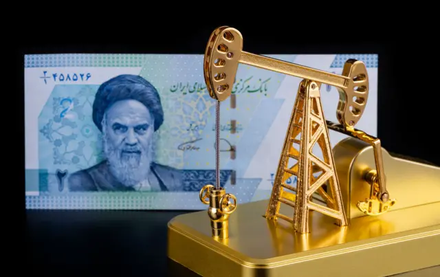 ماکت طلایی که دستگاه حفر نفت، پشت آن یک اسکناس جمهوری اسلامی در پسزمینه سیاه رنگ