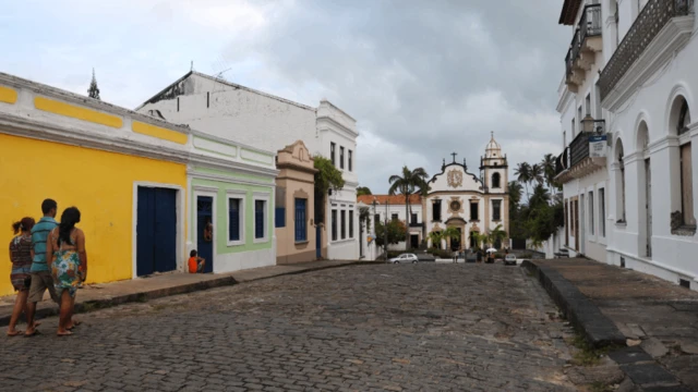 Várias pessoas caminhando entre casas coloridasroleta payOlinda,roleta paydireção à Basílica do Mosteiroroleta paySão Bento