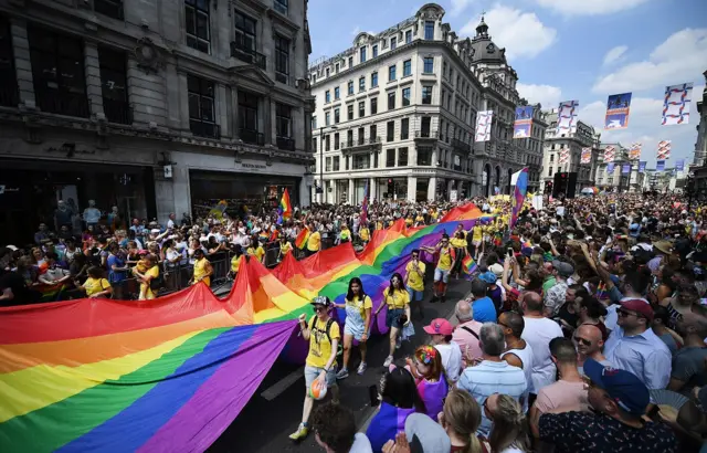 Participants carry a giant Rainbow flag as tens of thousands of people attend the annual London Pride Parade in London
