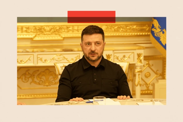 Зеленський сидить за столом, за ним стіна із золотими орнаментами