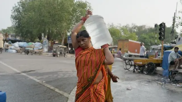बोतल लेकर जा रही महिला की तस्वीर.