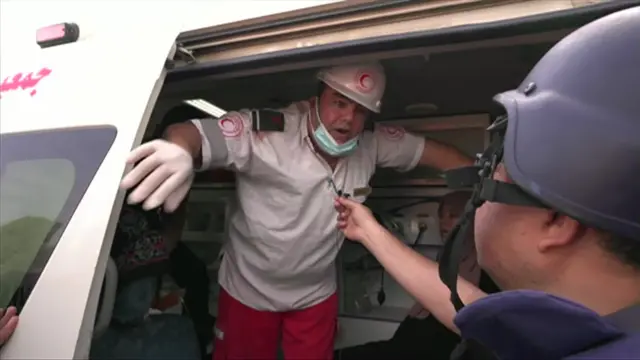 A paramedic inside his ambulance talking to Adnan Al Bursh 