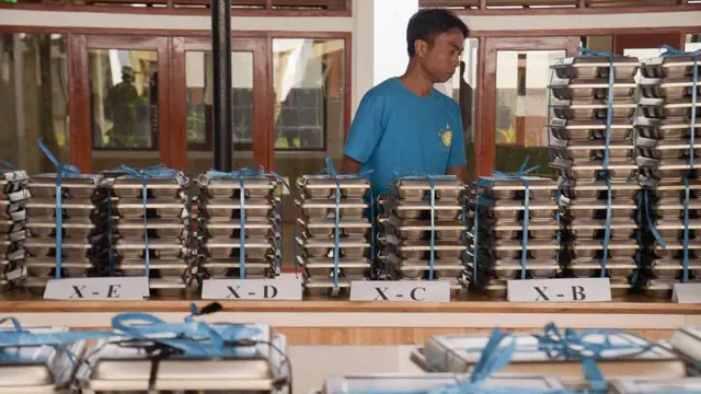 Seorang petugas menghitung makanan bergizi gratis yang akan dibagikan kepada siswa SMA di SMA Negeri 20 Bandung, Jawa Barat, Indonesia, pada 14 April 2025.