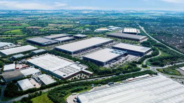 Vista aérea que muestra cómo podría verse la antigua planta de Honda en South Marston como Parque Panattoni. Se aprecian naves industriales plateadas con techos planos, árboles verdes y aparcamiento entre ellas. A lo lejos se ven campos verdes con la A419 y Swindon a la derecha de la foto.  