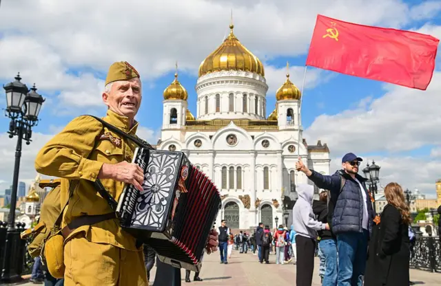 Um homem segura uma bandeira soviética.