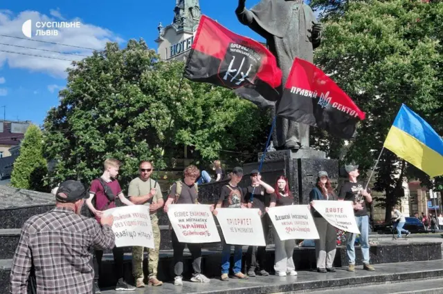 Протест проти мігрантів. Люди стоять рядком з плакатами 