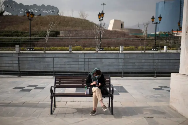 زنی در حال استفاده از گوشی هوشمند در شمال تهران