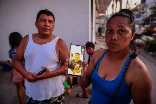 Os paisquais são os melhores sites de apostasBrian mostram foto dele na tela do celular