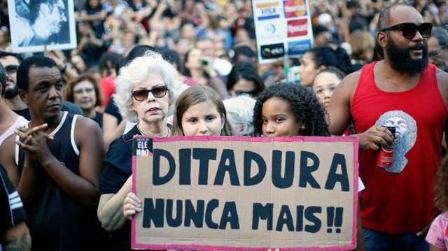 Duas meninas seguram uma placa que diz "Ditadura nunca mais" durante uma manifestação na praça da Cinelândia, no Rio de Janeiro, Brasil, em 31 de março de 2019