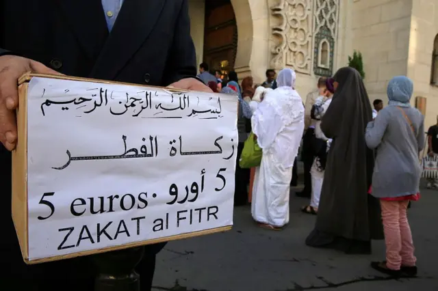 Distribution de l'aumône Zakat El Fitr devant une mosquée.
