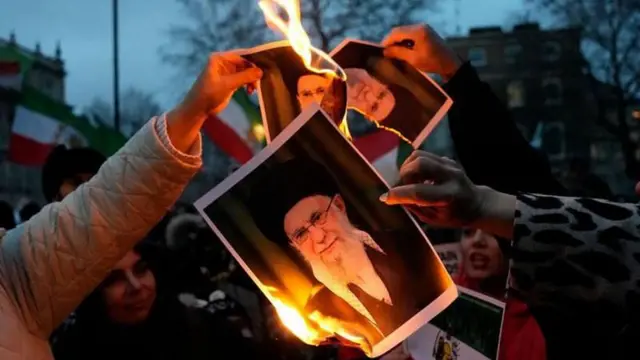 Manifestantes en Irán queman fotos de los dirigentes del régimen iraní.