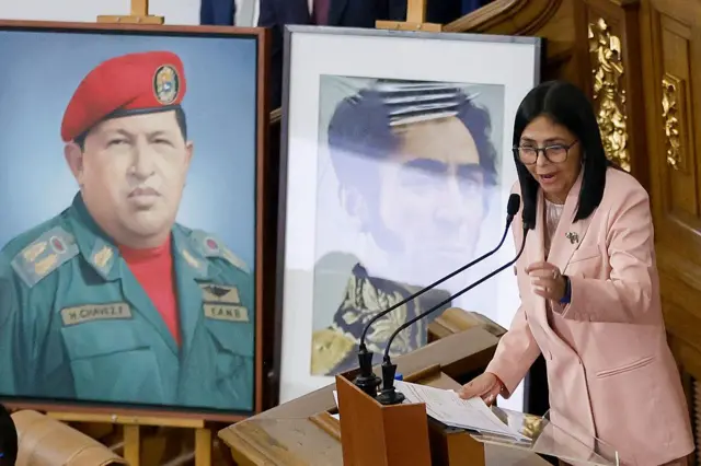 Delcy Rodríguez pronuncia un discurso ante un retrato de Hugo Chávez y otro de Simón Bolívar.